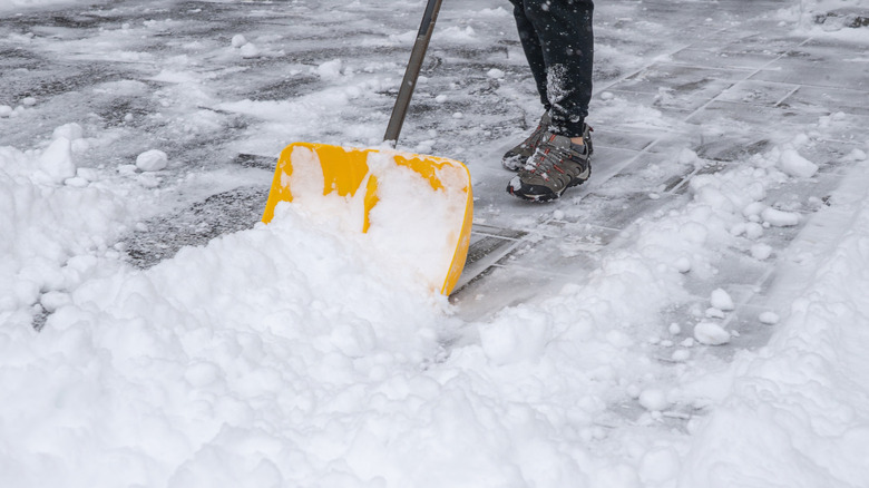 A yellow snow shovel being pushed