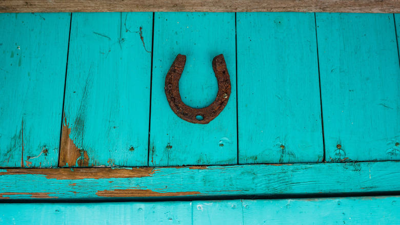 Rusty horseshoe hung on top of door