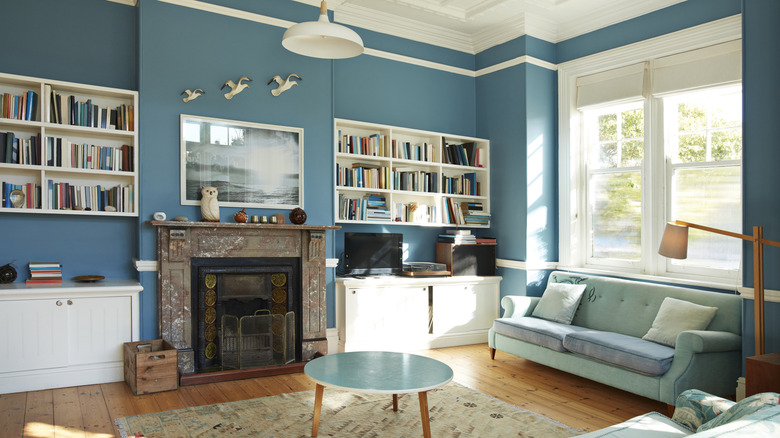 dark blue ornate fireplace in a room with floral wallpaper