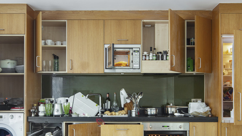 wooden cabinets in kitchen that reach to the ceiling and have some doors open
