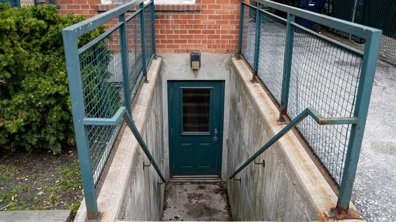 View of basement apartment entrance with stairs and metal railings