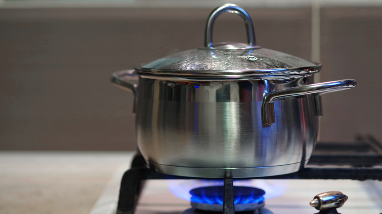 A pan sitting on a gas burner with a blue flame