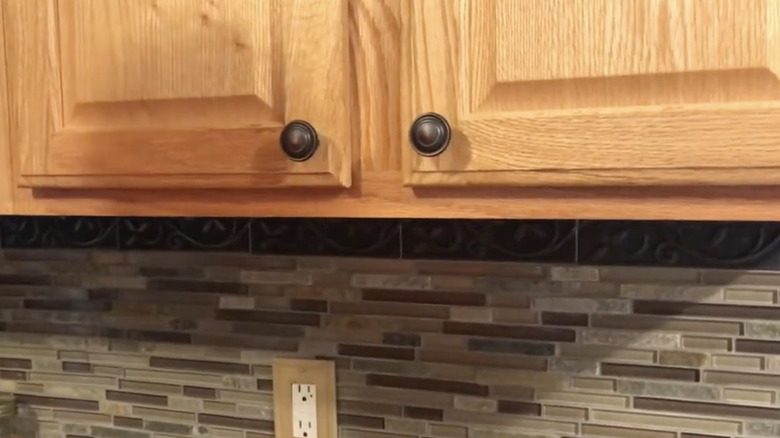Brass knobs installed on oak cabinet doors