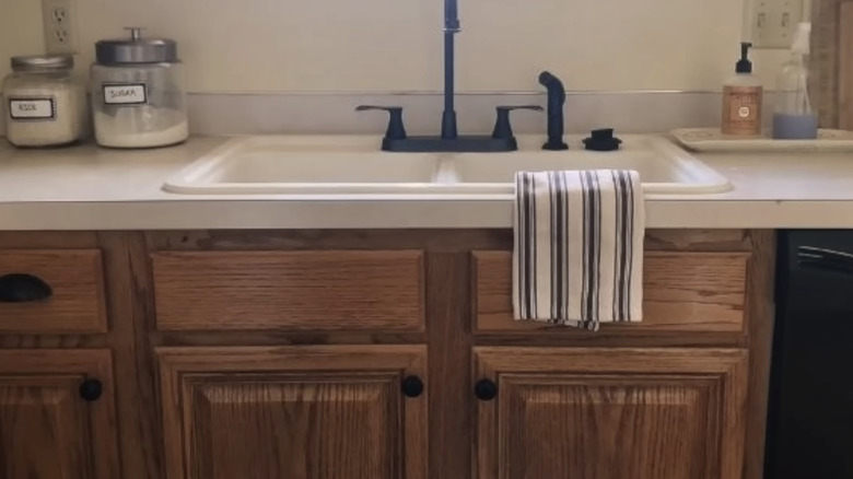 Cabinets below a sink with dark wood wax applied to them
