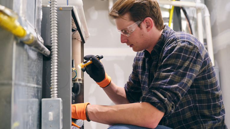 A man works on repairing a furnace