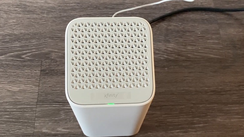 A white Xfinity modem blinking green