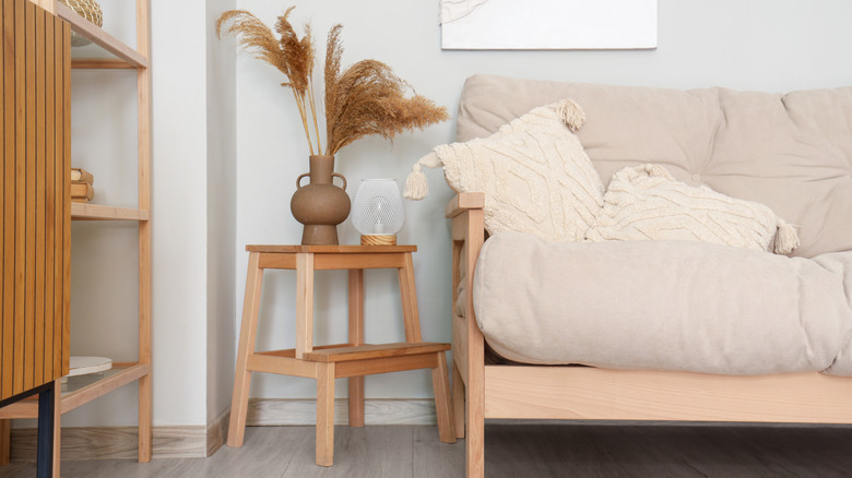 A living room couch with step stool as side table