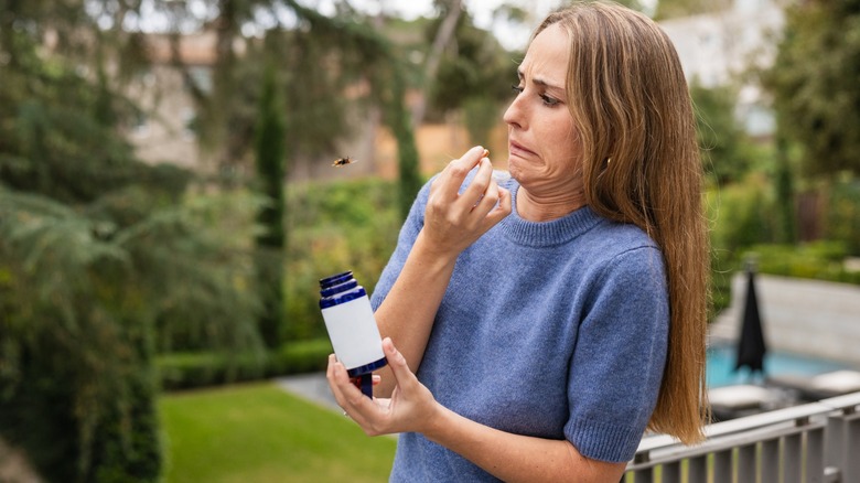 a woman on a porch bothered by a wasp