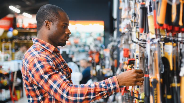 A man selecting an item for purchase at a hardware store