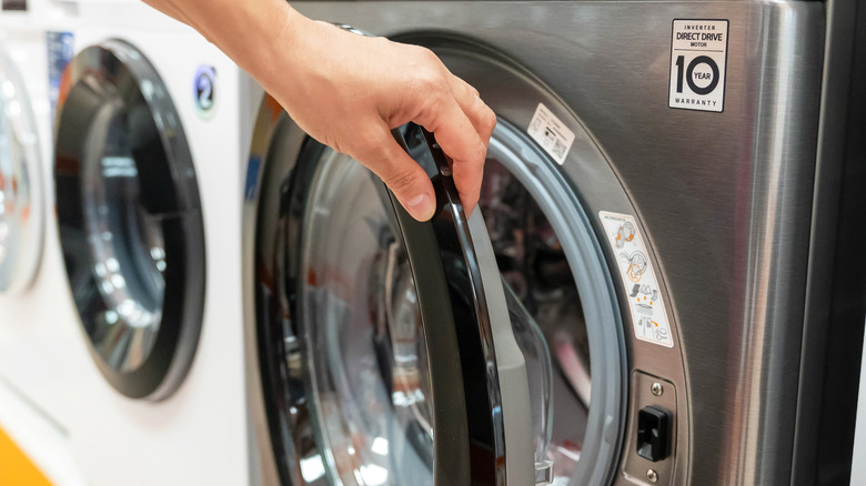 A shopper examining a front-loading washing machine