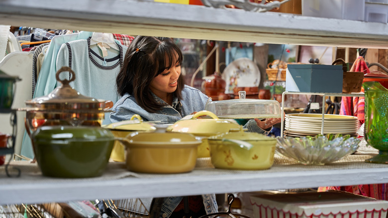 A woman shopping in the kitchenware section of the thrift store