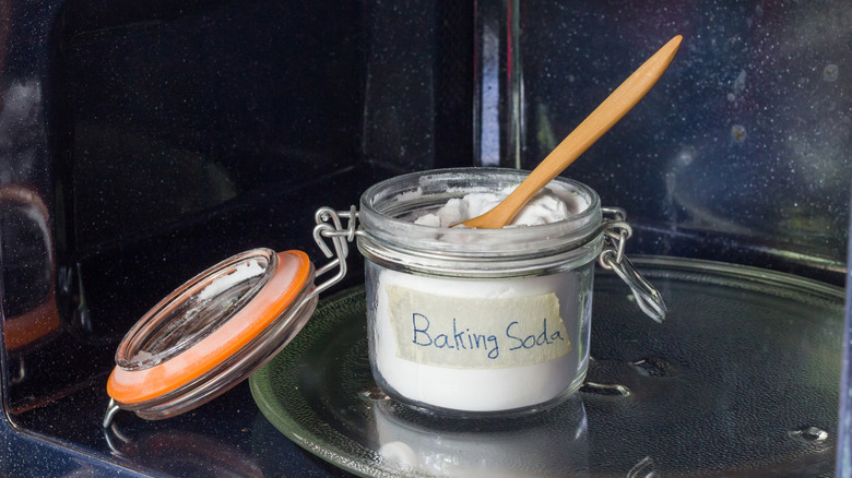 A glass jar of baking soda in the microwave