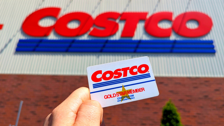 hands holding a Costco membership card outside a store