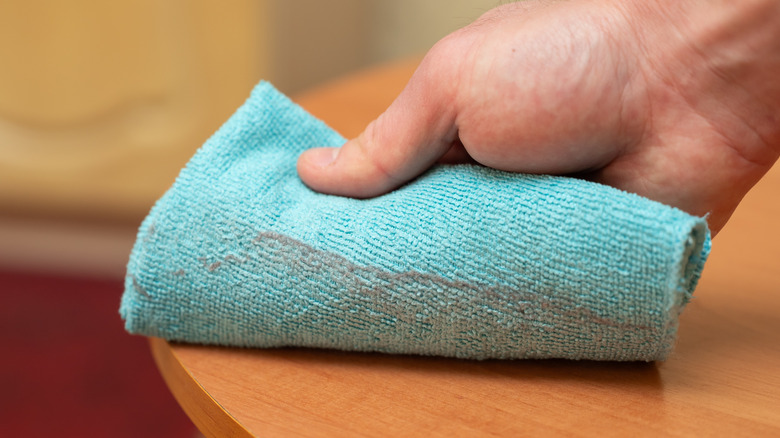 Hand dusting wood furniture with microfiber cloth