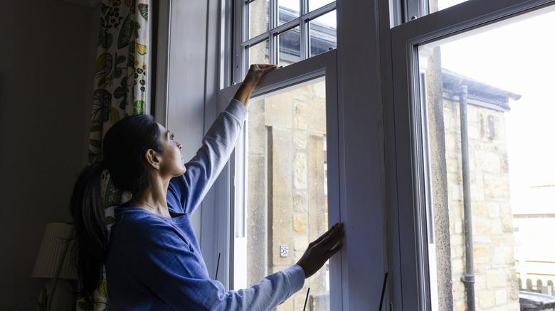 A woman closing her windows
