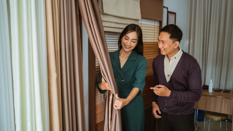 Two people discussing window treatments in a store