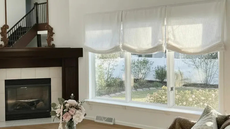 A living room with relaxed Roman shades covering the windows