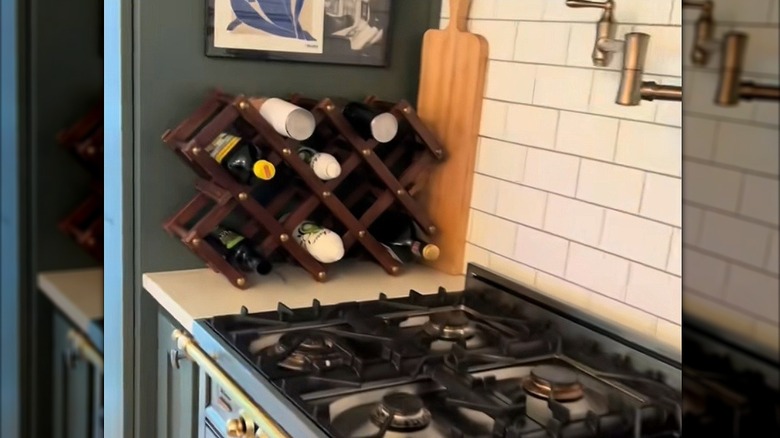 Kitchen sprays, oils, and vinegars on lattice-style wine rack on beige kitchen countertop