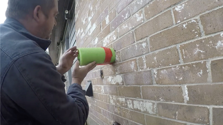 Man installing pool noodle faucet cover