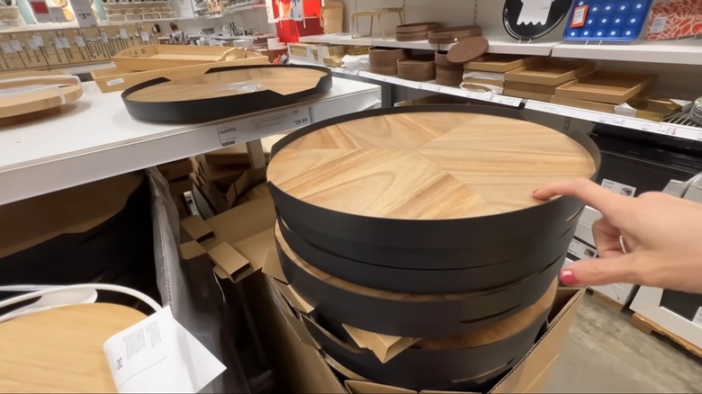A person browsing wooden lazy Susan products at IKEA in store