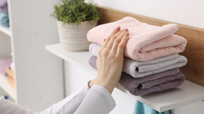Someone grabbing a towel from a stack