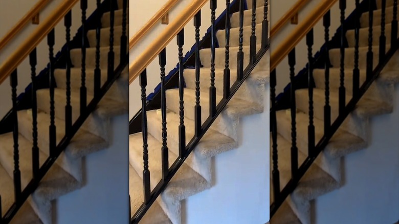 Finished staircase banister paint job featuring black spindles.