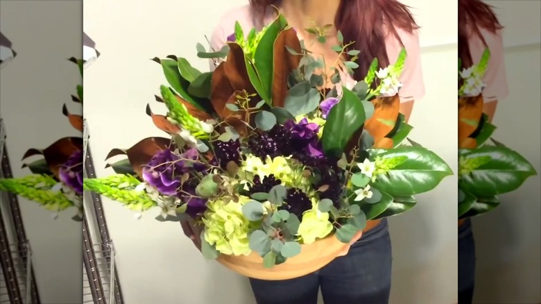 Florist golding faux flowers inside IKEA bowl turned planter