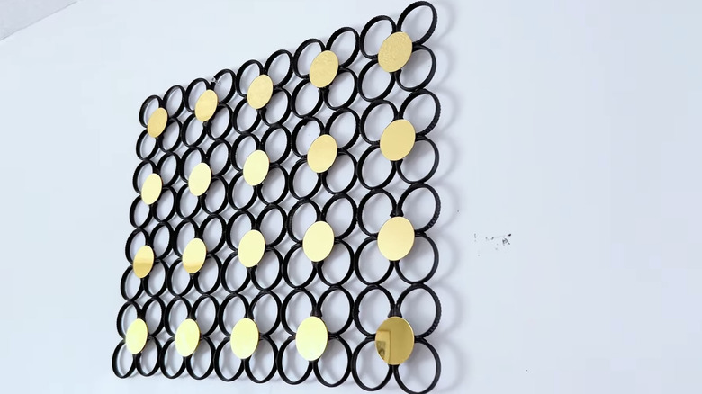 DIY wall decor made from shower rings painted black with gold metallic circles on top