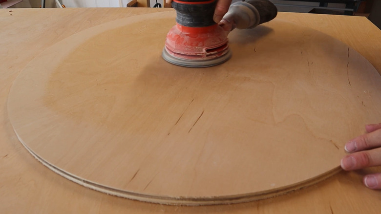 Person sanding a wood round