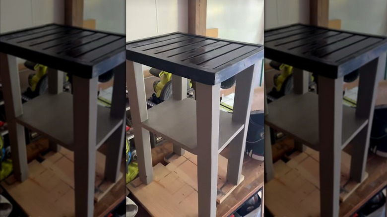 The DIY, slatted side table with a gray base and a black tabletop.