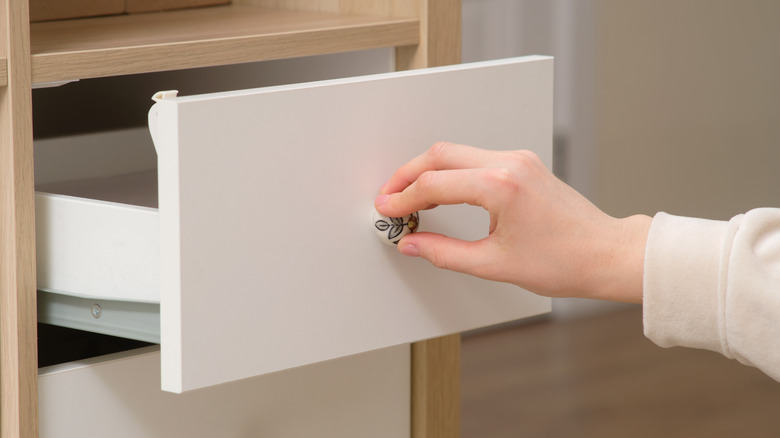 Person's hand opening a drawer
