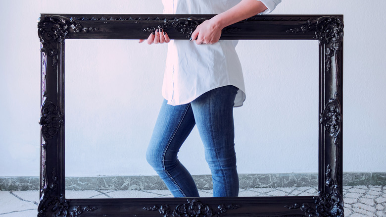 Woman holding giant empty frame