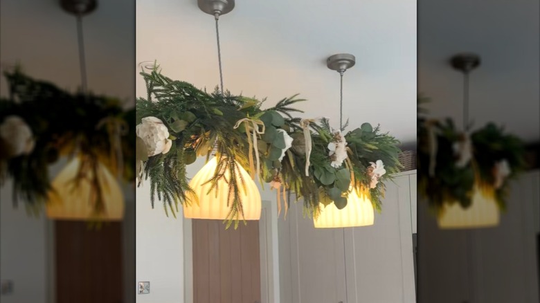 White ribbed pendant lights decorated with DIY eucalyptus garland above kitchen island