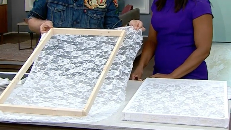 People installing lace fabric on DIY wood fly screen frame