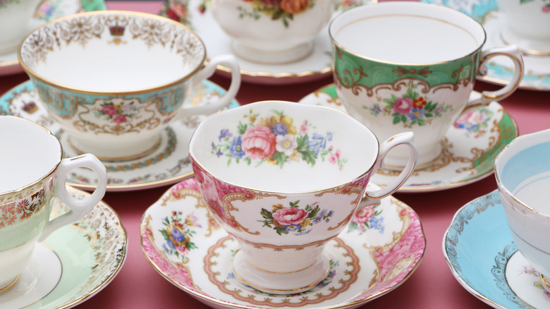 Floral china teacups and saucers on pink tablecloth
