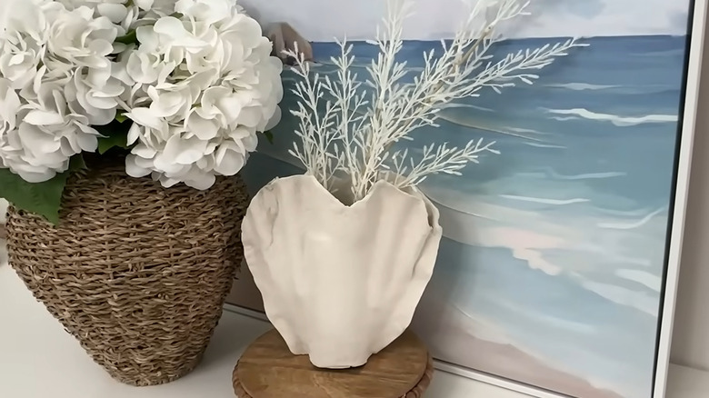 DIY seashell-shaped vase with white dried branches in it