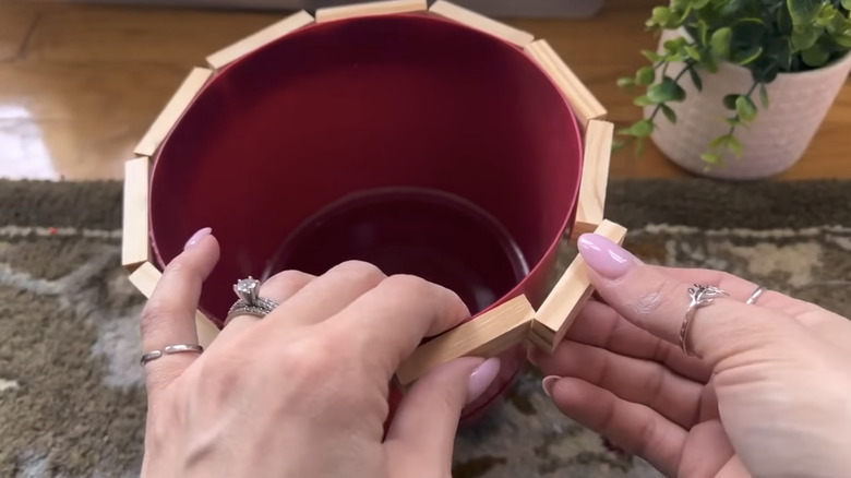 hand gluing wood blocks to planter