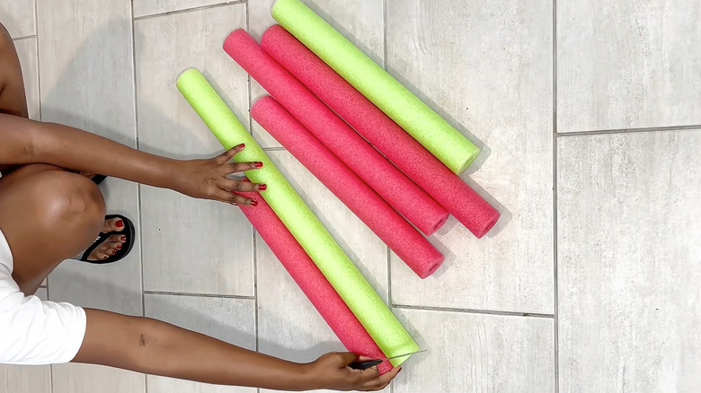 Woman cutting pool noodles for wall art DIY