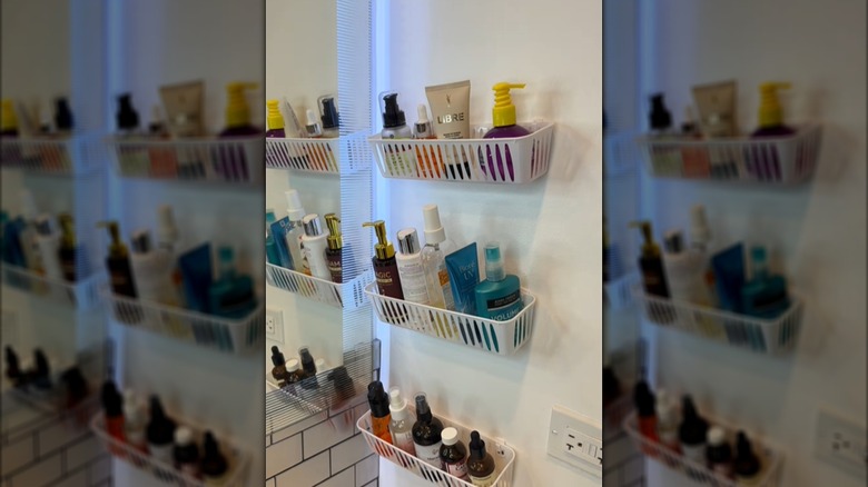Three plastic Dollar Tree baskets hanging on the wall next to the sink with toiletries in them