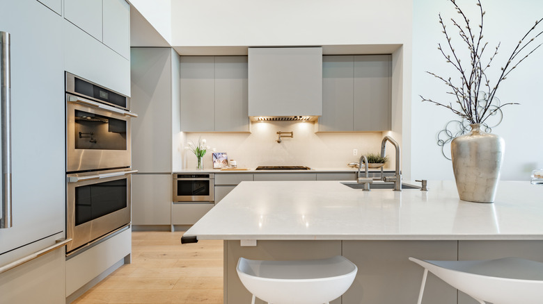 Modern kitchen with range hood behind cabinets