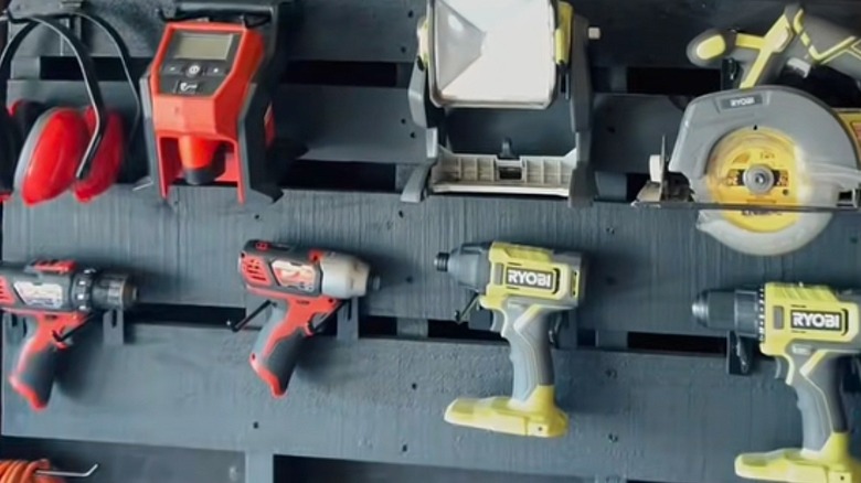 Home improvement tools and devices hanging on blue-gray pallet wall