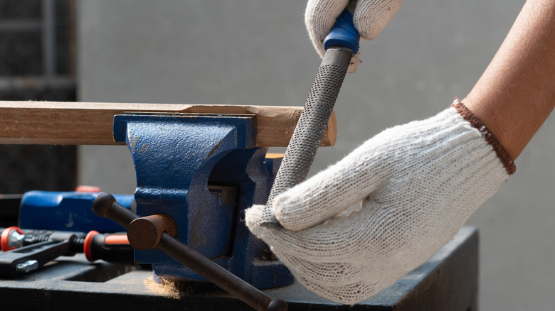 Using a rasp to shape a piece of wood
