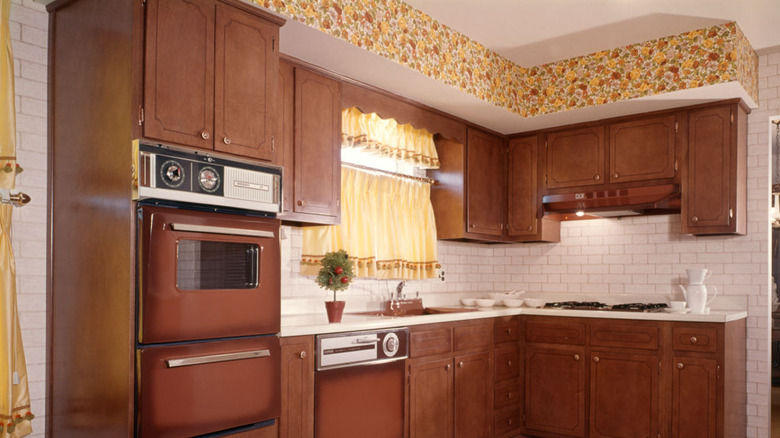 A vintage kitchen with wallpaper only above the cabinets