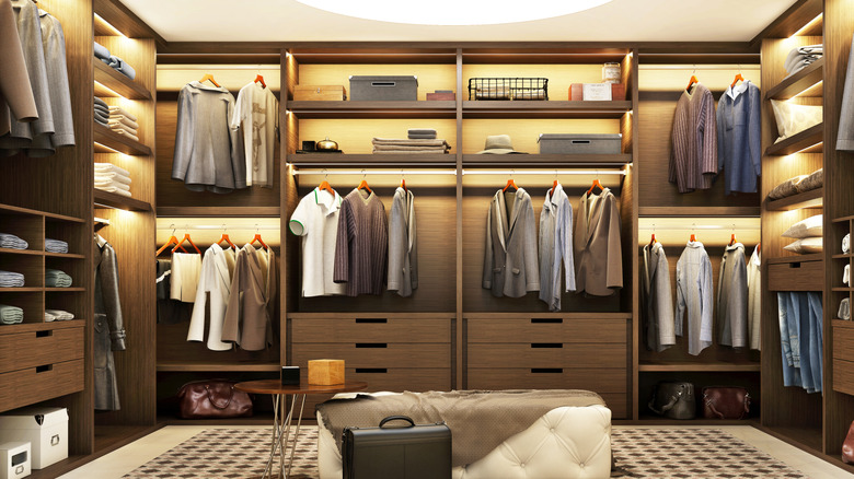 An enormous modern walk-in closet with bench