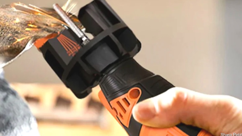 Person sharpening a blade with a Sharp Pebble sharpener