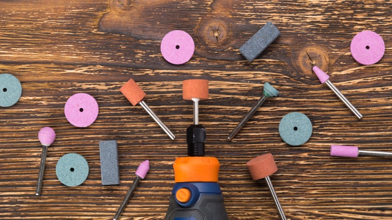 Rotary tool with selection of accessories displayed on a wooden surface