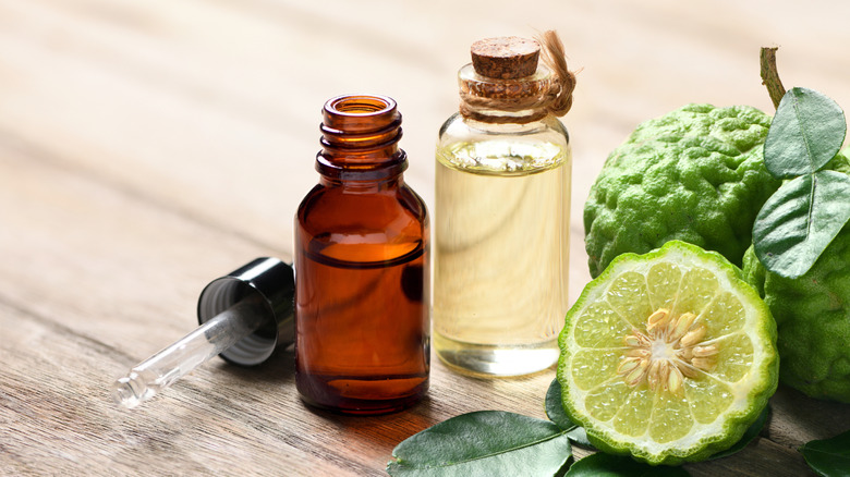 two bottles of bergamot essential oil next to a bergamot orange