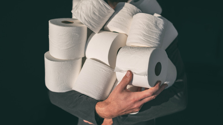 Man carrying too much toilet paper