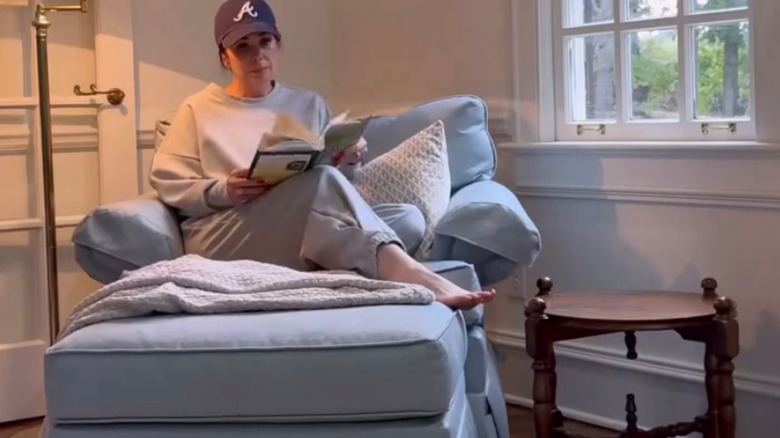 Woman sitting in blue chair next to side table