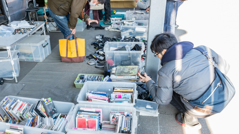 Young people looking through boxes of secondhand gadgets